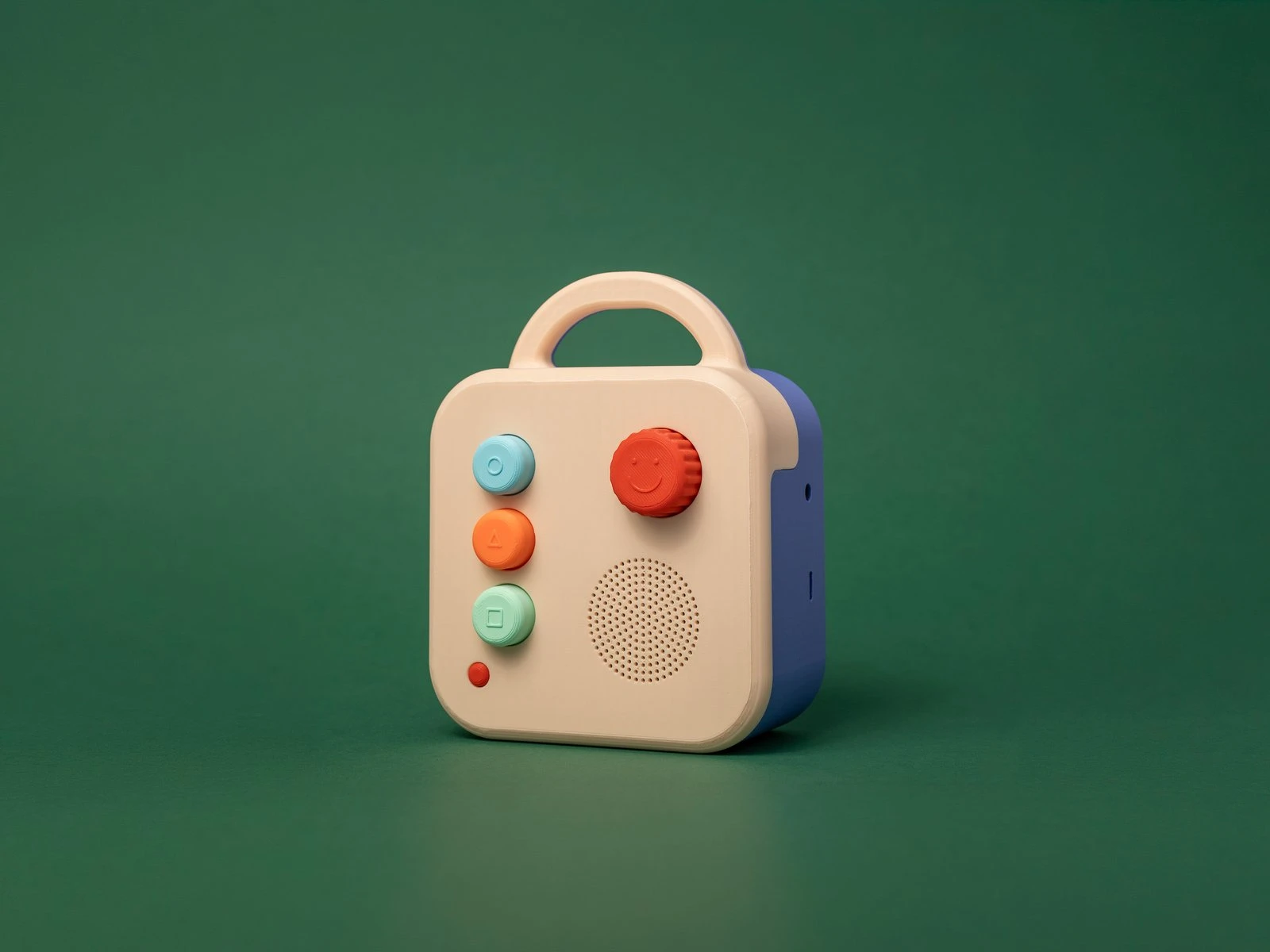 A Koobiba audio player, cream with a purple back, on a green background